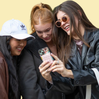 3 girls looking at a phone together